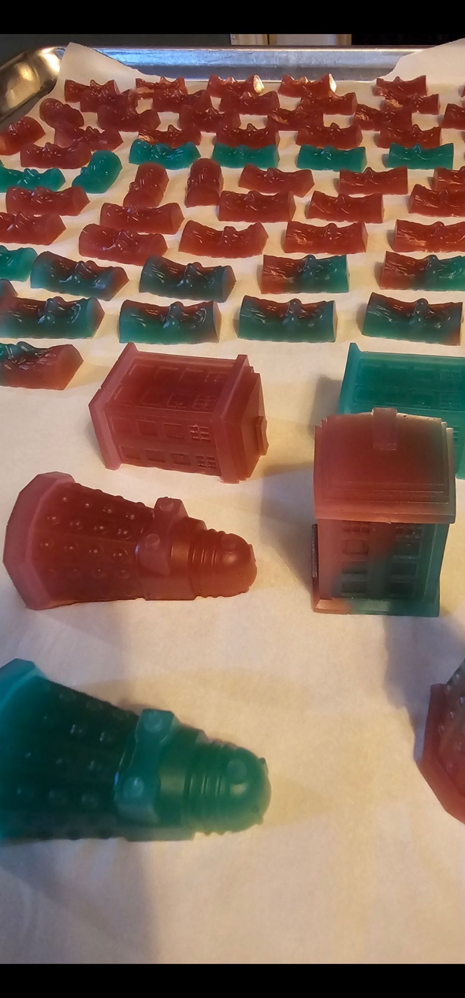 Rows of novelty gummies shaped like pop culture icons drying on trays